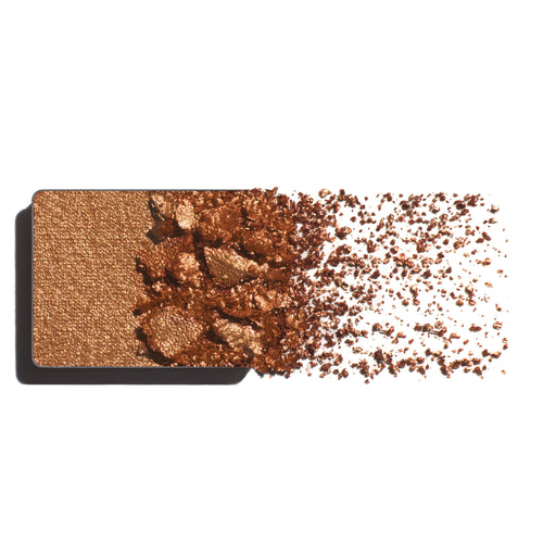 Makeup eyeshadow refill with rich bronze powder on a white background