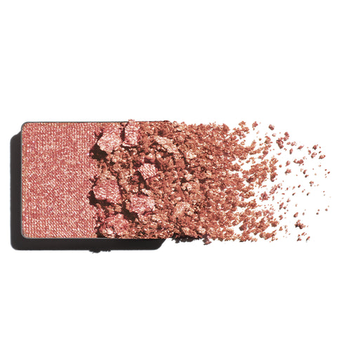 Makeup eyeshadow refill with peach-gold powder on a white background