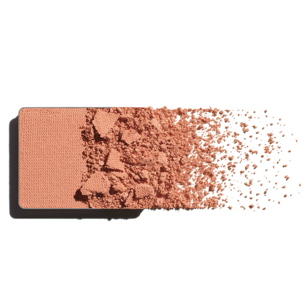 Makeup eyeshadow refill with soft apricot powder on a white background