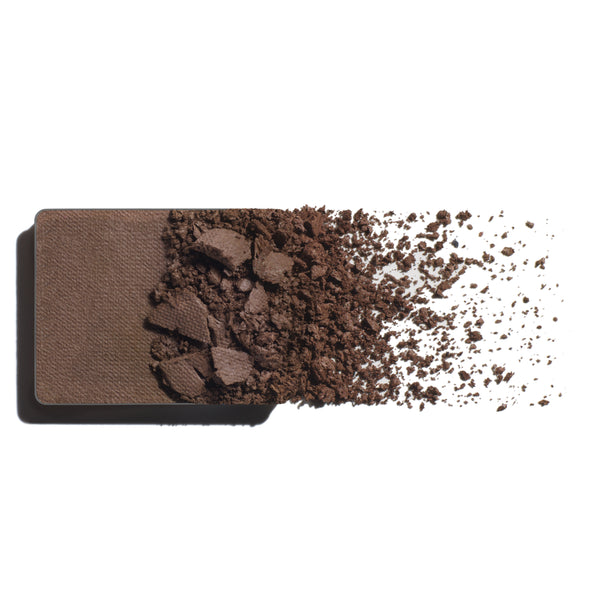 Makeup eyeshadow refill with cool brown powder on a white background