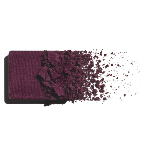 Makeup eyeshadow refill with vibrant mulberry powder on a white background